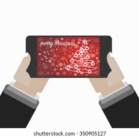 Christmas Greeting on the screen of the smartphone. Isolated on white. Holding in hands