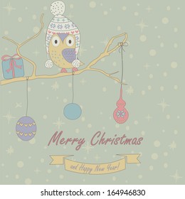 Christmas and Happy New Year greeting card with cute owl in winter cap sitting on branch as on christmas tree with christmas decoration and gift box.