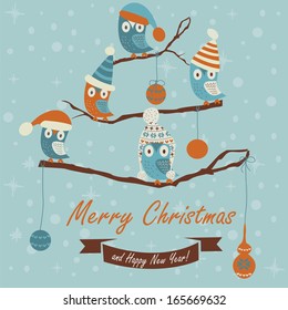 Christmas and Happy New Year greeting card with cute owls in winter caps sitting on branches.  Cartoon style.