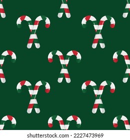 Christmas holiday seamless pattern with candy canes on a green background. Vector background for printing, winter holidays, greeting cards, fabric, textiles, and wrapping paper.