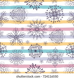 Christmas holiday seamless pattern with snowflakes on a striped background. Colorful decoration for wrapping paper or holiday packaging.