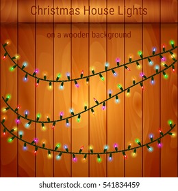 Christmas house lights on a wooden background. Luminous garlands for greeting cards, invitations and gift cards