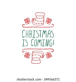 Christmas label with text on white background. Christmas is coming. Typographic element with gifts and sock. Handdrawn christmas badge.