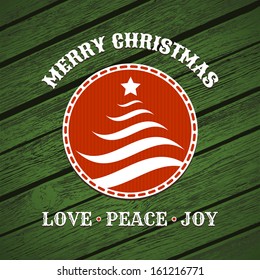 Christmas label with christmas tree on green wood background