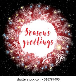 Christmas lettering and calligraphy design. Season's Greetings handwritten phrase in Xmas wreath frame. Modern holiday hand writing font. Hand drawn holiday design elements for greeting card. Vector. 
