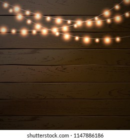 Christmas lights isolated on dark wooden background. Glow garland. Vector glow xmas light bulbs on wires.