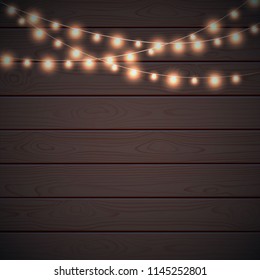 Christmas lights on dark wooden background. Glow garland. Vector glow xmas light bulbs on wires. Christmas banner with place for your design.