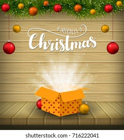 Christmas miracle. Wood background with christmas tree, decorations and magic gift. 