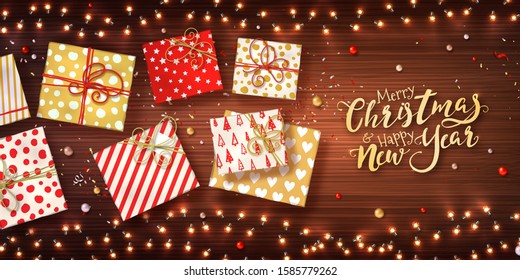 Christmas and new year banner with gift boxes, xmas garlands of lights, baubles and glitter confetti on wooden texture. Horizontal holiday background with glowing LED light bulbs. Vector