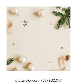 Christmas, New Year holiday composition. Mock up frame with blank copy space made of fir needle branches, ribbon and Christmas baubles on beige background. Flat lay, top view festive concept.