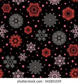 Christmas and New Year theme. Vector winter design on black background. Happy smiling orange and pink snowflakes seamless pattern. Snowflakes decorated with circles and dots.