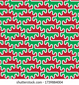 Christmas and New Year themed abstract seamless pattern. Simple geometric forms in red and green with white outline. Raindeer's antlers and snow-covered fir branches. Perfect design for gift wrapping.