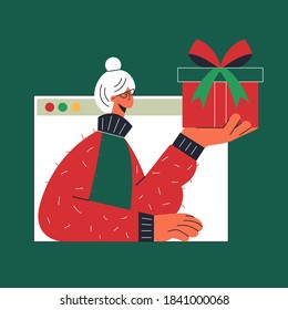 Christmas online virtual present from the old woman. Grandmother sends a gift to a child. Video chat with the family concept. People sharing presents on the internet and celebrating Xmas. Covid-19 di