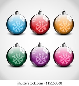 Christmas ornaments in blue, red, orange, green, purple and pink color with snow flakes on them. Has gray and white background.