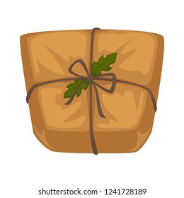 Christmas parcel in craft paper with rope and holly leaves