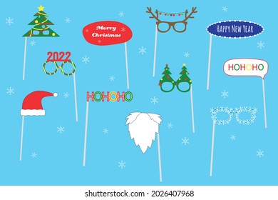 Christmas party photo booth set. Winter Holidays party concept for selfie. Glasses, Xmas trees, Santa beard, 2022, antlers, Santa hat on sticks