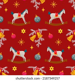 Christmas pattern with childish rocking horses on red background. Christmas bells. Pine branch. Holiday design for Textile, Fabrics, Wrapping paper, Gift boxes.