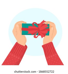 Regalo navideño en manos con suéter rojo