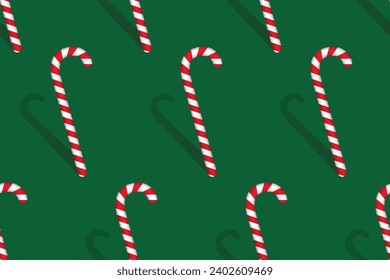 Christmas red and white candy cane with shadow on green background. Seamless pattern. Vector illustration.