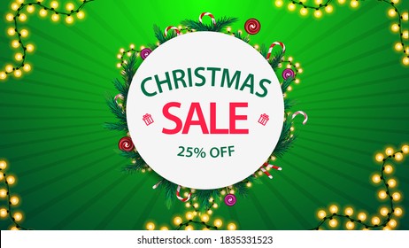 Venta de Navidad, hasta un 25% de descuento, banner de descuento verde y blanco con marco redondo de ramas de árboles de Navidad y guirnaldas alrededor de un círculo blanco con oferta, botón y marco de garland sobre fondo verde