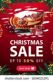 Christmas sale, up to 50% off, vertical red discount banner with abstract reggad shape, garland frame, frame made of Christmas tree branches, button and Santa Claus sleigh with pile of presents