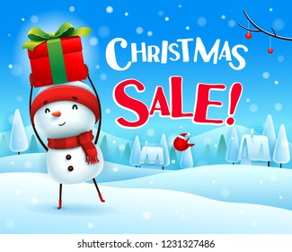 Christmas Sale! Cheerful snowman holds up gift present in Christmas snow scene winter landscape.