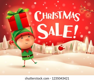 Christmas Sale! Little elf holds up gift present in Christmas snow scene winter landscape.