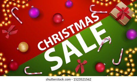 Christmas sale, modern red and green discount banner with candy cane, Christmas ball and garland on the table, top view