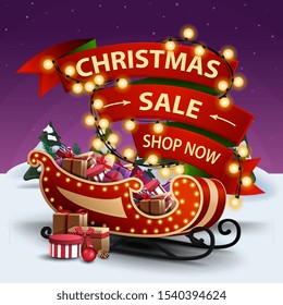 Christmas sale, shop now, discount banner with red ribbon wrapped in garland and Santa Sleigh with presents