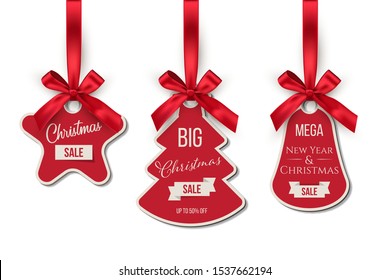 Christmas sale tags set. Big winter holidays discounts. Fir tree, bell, star shapes labels hanging on red ribbons isolated on white background. New Year shopping special offers stickers collection