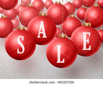 Christmas sale text in christmas red balls hanging in a winter snow background for discounts and promotions. Vector illustration.
