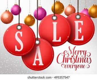 Christmas sale vector design in hanging red sale tags with colorful christmas balls in winter snowflakes background. Vector illustration.
