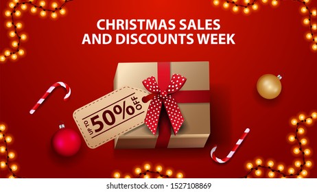 Christmas sales and discount week, red banner with gift box, Christmas balls and candy cane, top view