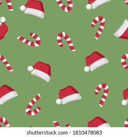 Christmas seamless background with red hat of Santa Claus and candy canes on a green background. Vector