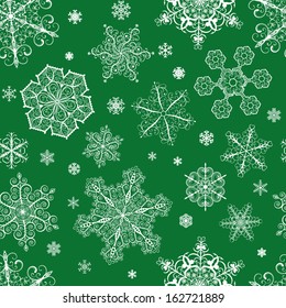 Christmas seamless pattern from big and small white snowflakes on green background