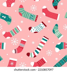 Christmas seamless pattern with bright Christmas socks and snowflakes on a pink background