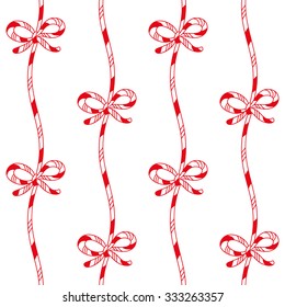 Christmas seamless pattern. Candy cane striped cords with bows on a white background.