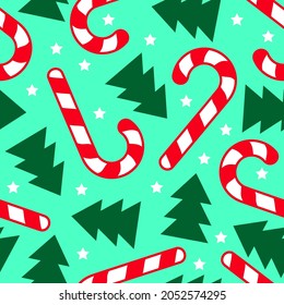 Christmas seamless pattern with candy sticks and firs. Striped Lollipops and Christmas trees on green background.