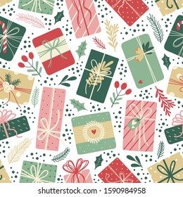 Christmas seamless pattern with gifts, berries, holly leaves, snow balls, fir branches. Vector background on white. Cute illustration for fabric, wrapping paper, postcard design.