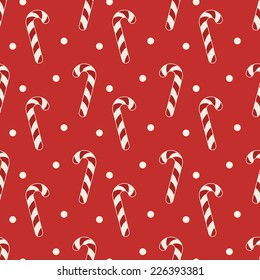 Christmas seamless pattern. Red and cream colors. Illustrations of candy canes and on red polka dot background