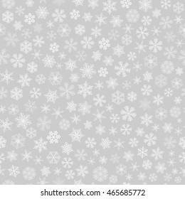Christmas seamless pattern of small snowflakes, white on gray