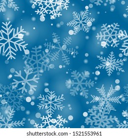 Christmas seamless pattern of snowflakes of different shapes, sizes and transparency in light blue colors