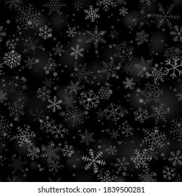Christmas seamless pattern of snowflakes of different shapes, sizes and transparency, on black background