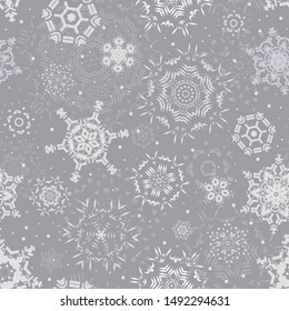Christmas seamless pattern with snowflakes on a light gray (silver) background. New year winter print. Falling snow. Vector illustration.