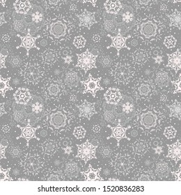 Christmas seamless pattern with snowflakes on a light gray background. Falling snow backdrop. Winter ornament. Christmas print, Wallpaper, pattern for textiles, wrapping paper. Vector.