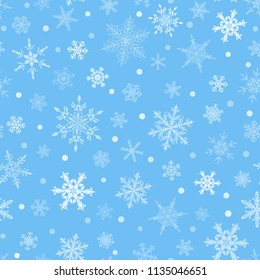 Christmas seamless pattern of snowflakes, white on light blue background.
