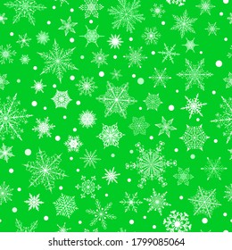 Christmas seamless pattern of various complex big and small snowflakes, white on green background