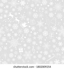 Christmas seamless pattern of various snowflakes and holiday symbols, white on gray background