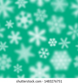 Christmas seamless pattern of white defocused snowflakes on turquoise background