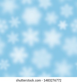 Christmas seamless pattern of white defocused snowflakes on light blue background